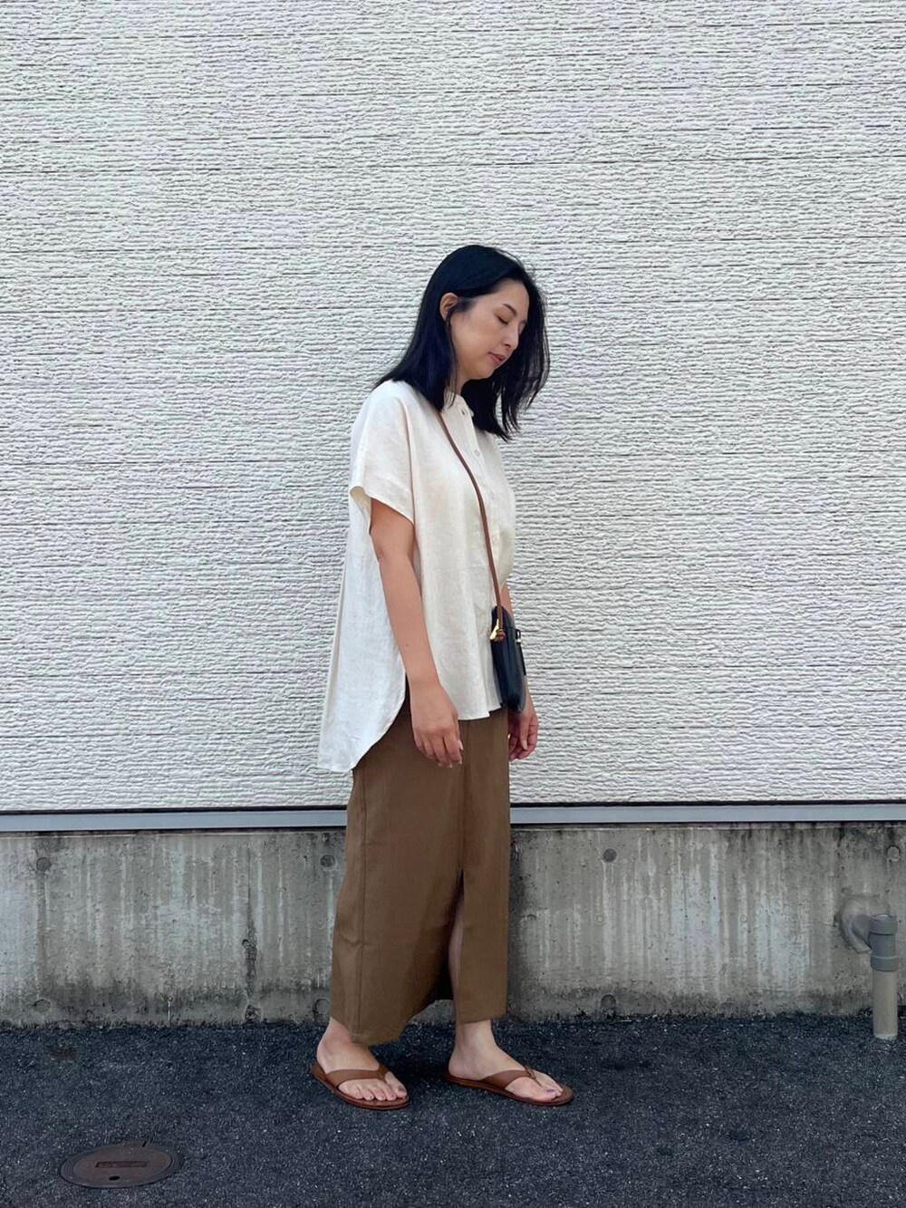 ブラック系のショルダーバッグ、ベージュ系のシャツ/ブラウス、イエロー系のスカートを着用したレディースの夏コーディネートの2枚目の写真