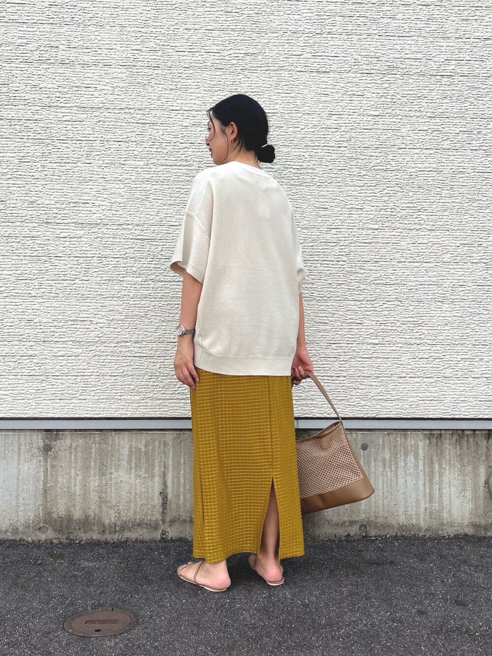 ベージュ系のショルダーバッグ、ホワイト系のニット/セーター、イエロー系のスカートを着用したレディースの秋コーディネートの2枚目の写真