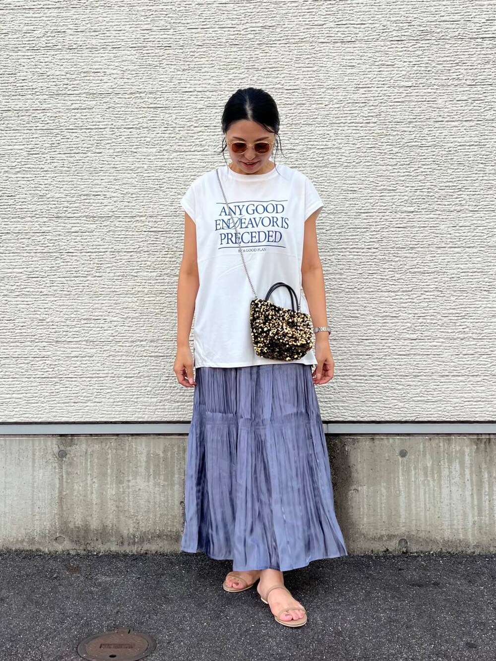 ゴールド系のショルダーバッグ、ホワイト系のTシャツ/カットソー、ブルー系のスカートを着用したレディースの夏コーディネートの2枚目の写真