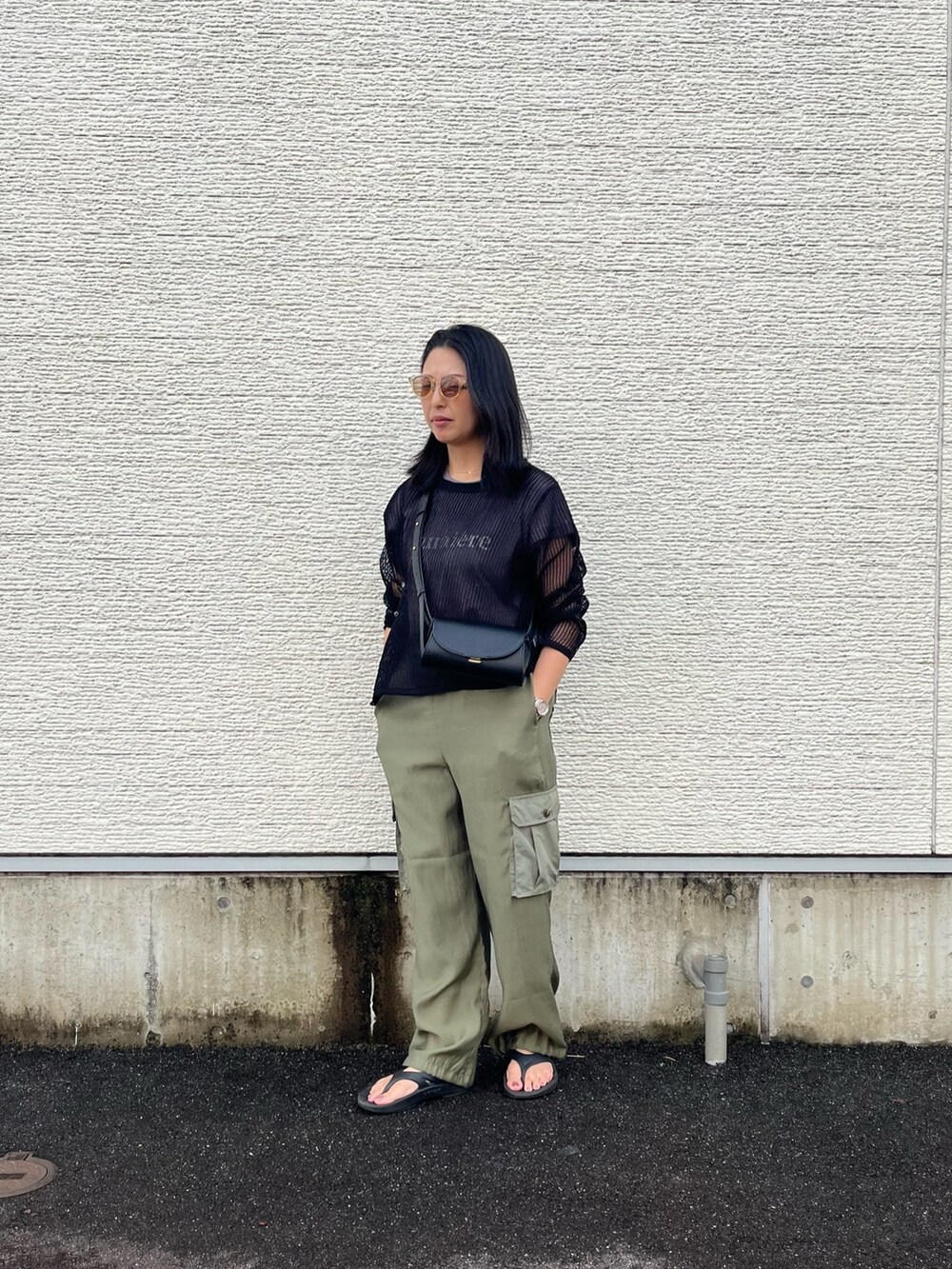 ブラック系のニット/セーター、グレー系のTシャツ/カットソー、グリーン系のカーゴパンツを着用したレディースの夏コーディネートの4枚目の写真