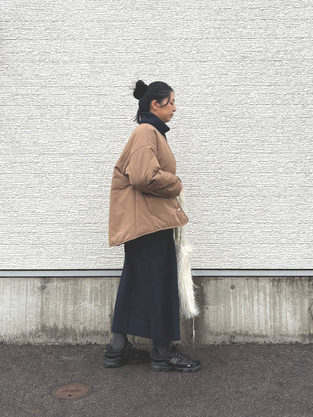 ブルー系のワンピース、イエロー系のダウンジャケット/コート、ホワイト系のトートバッグを着用したレディースの冬コーディネートの2枚目の写真