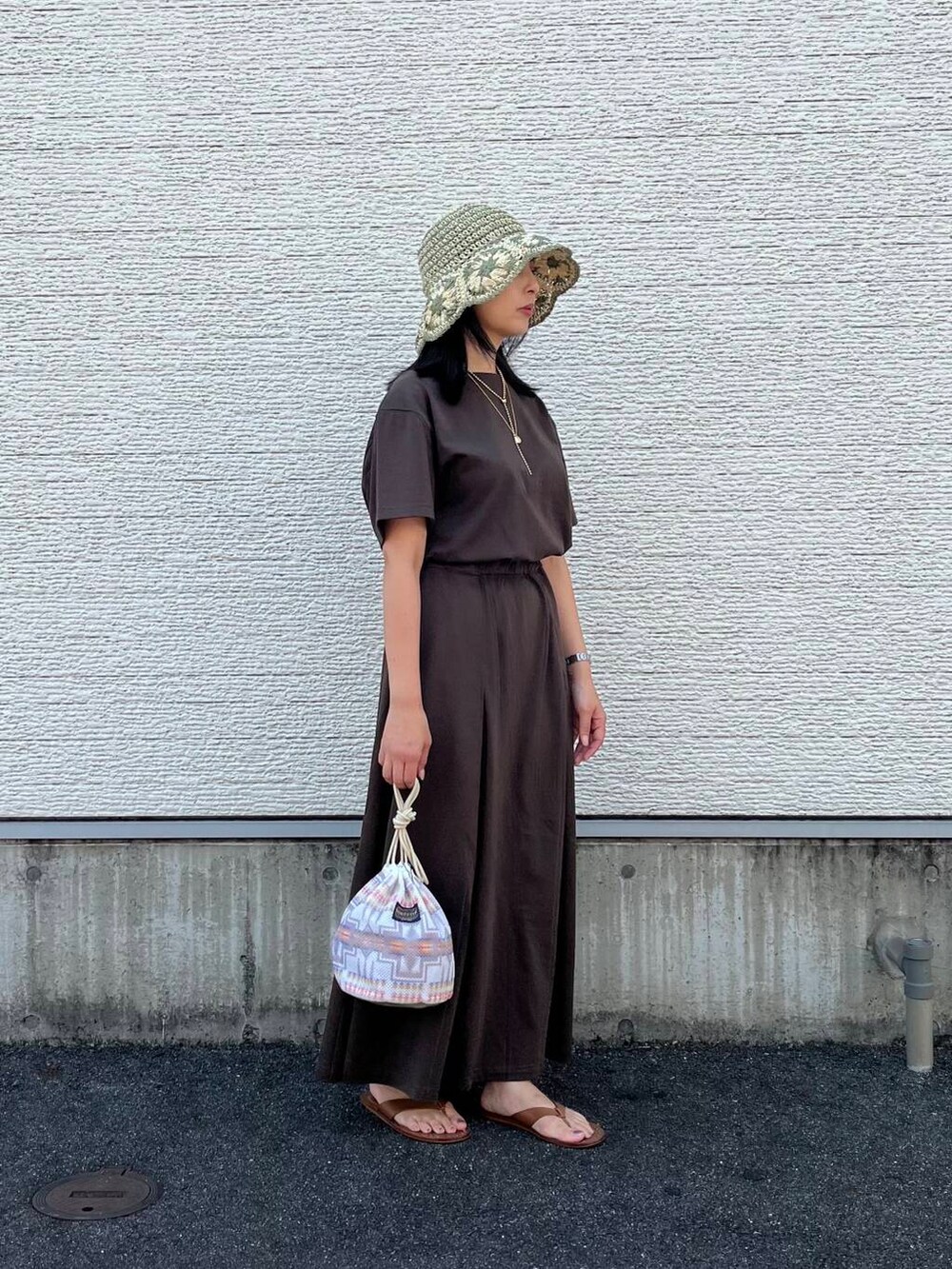 ホワイト系のショルダーバッグ、ブラウン系のワンピース、ホワイト系のハットを着用したレディースの夏コーディネートの2枚目の写真