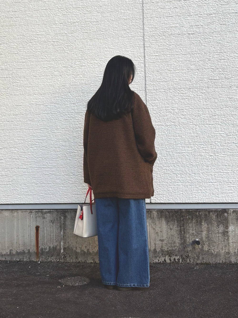 ホワイト系のニット/セーター、ブラウン系のその他アウター、ブルー系のデニムパンツを着用したレディースの冬コーディネートの3枚目の写真