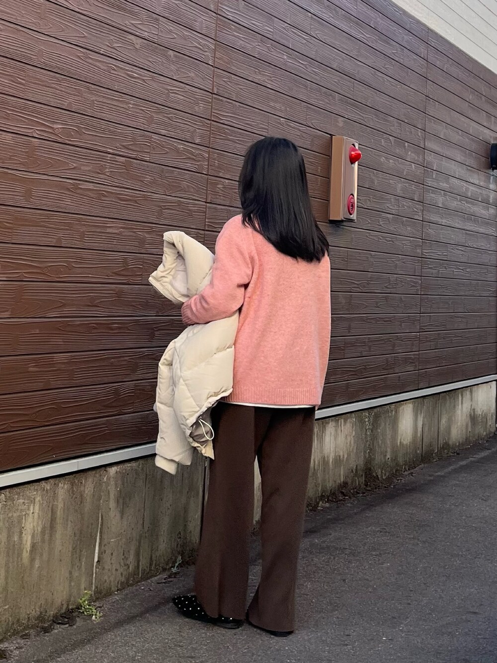 ピンク系のニット/セーター、グレー系のダウンジャケット/コート、ホワイト系のTシャツ/カットソーを着用したレディースの冬コーディネートの4枚目の写真