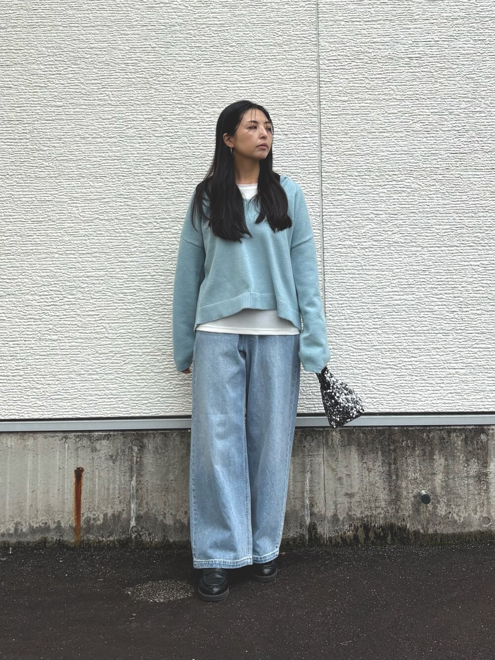 ブルー系のニット/セーター、ホワイト系のTシャツ/カットソー、ブルー系のデニムパンツを着用したレディースの秋コーディネートの4枚目の写真