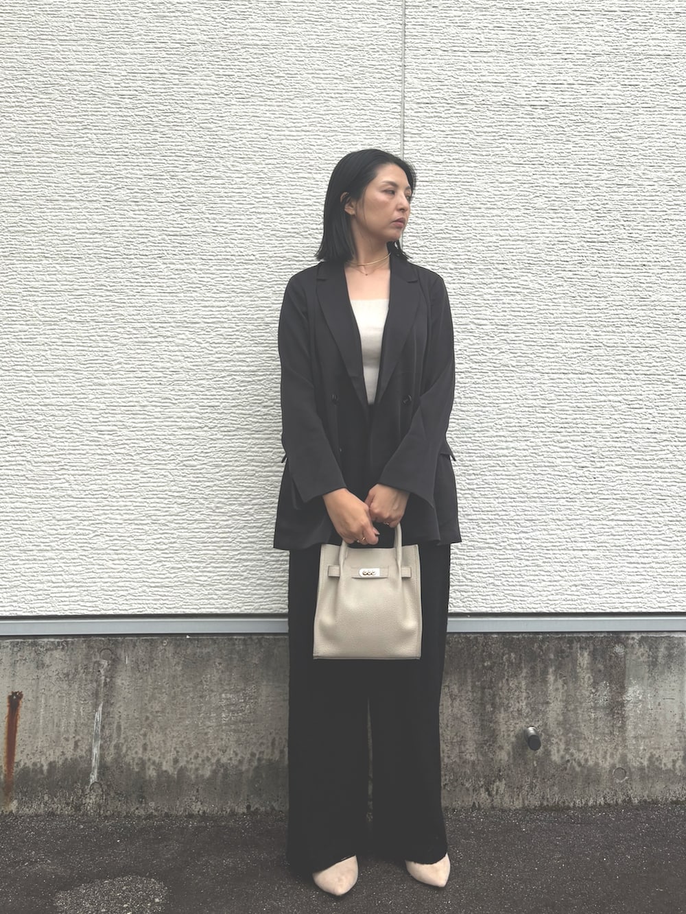 ブラック系のその他アウター、ブラック系のその他パンツ、グレー系のハンドバッグを着用したレディースの秋コーディネートの4枚目の写真