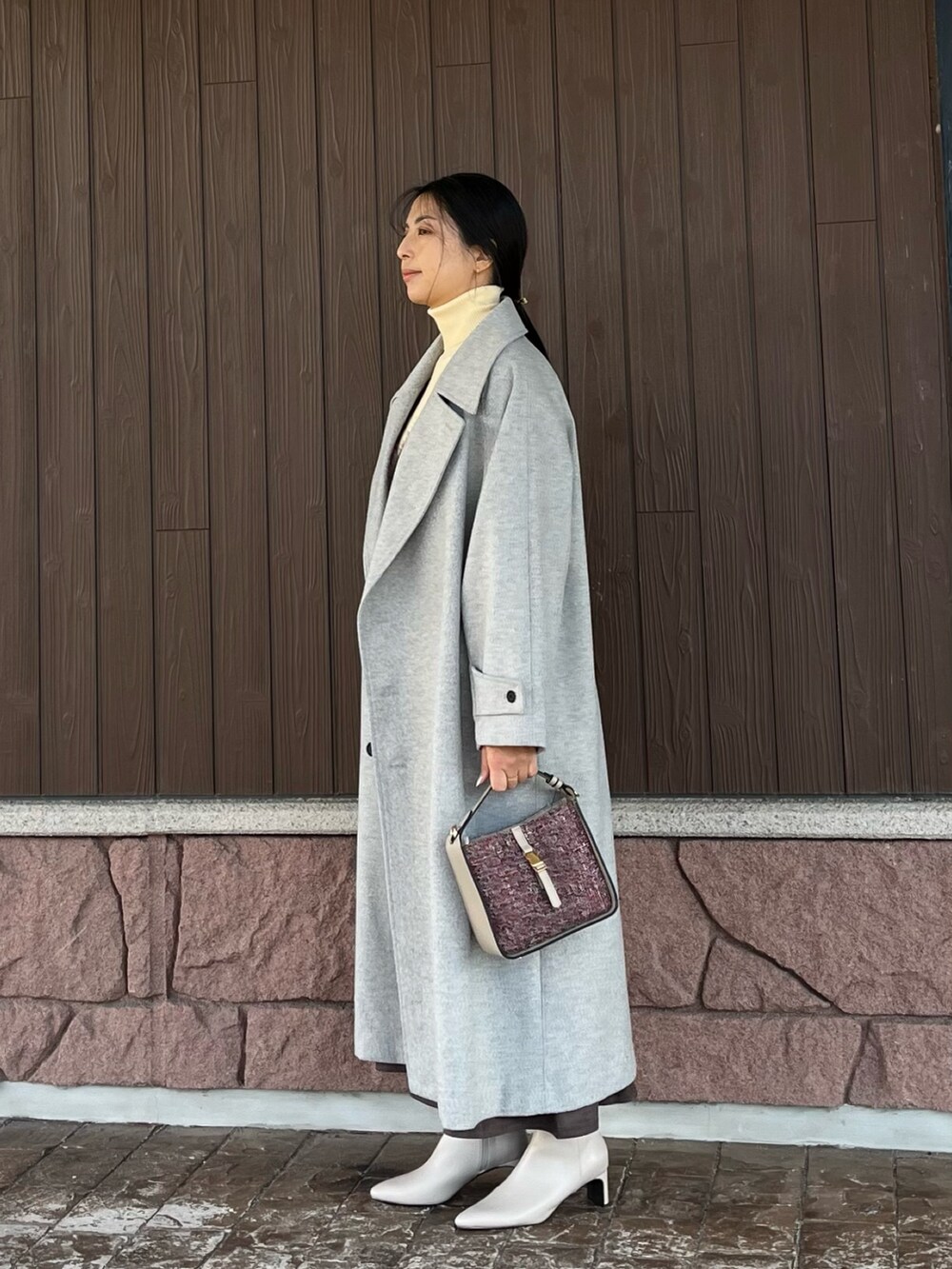 ホワイト系のニット/セーター、ブラウン系のニット/セーター、グレー系のブーツを着用したレディースの冬コーディネートの2枚目の写真