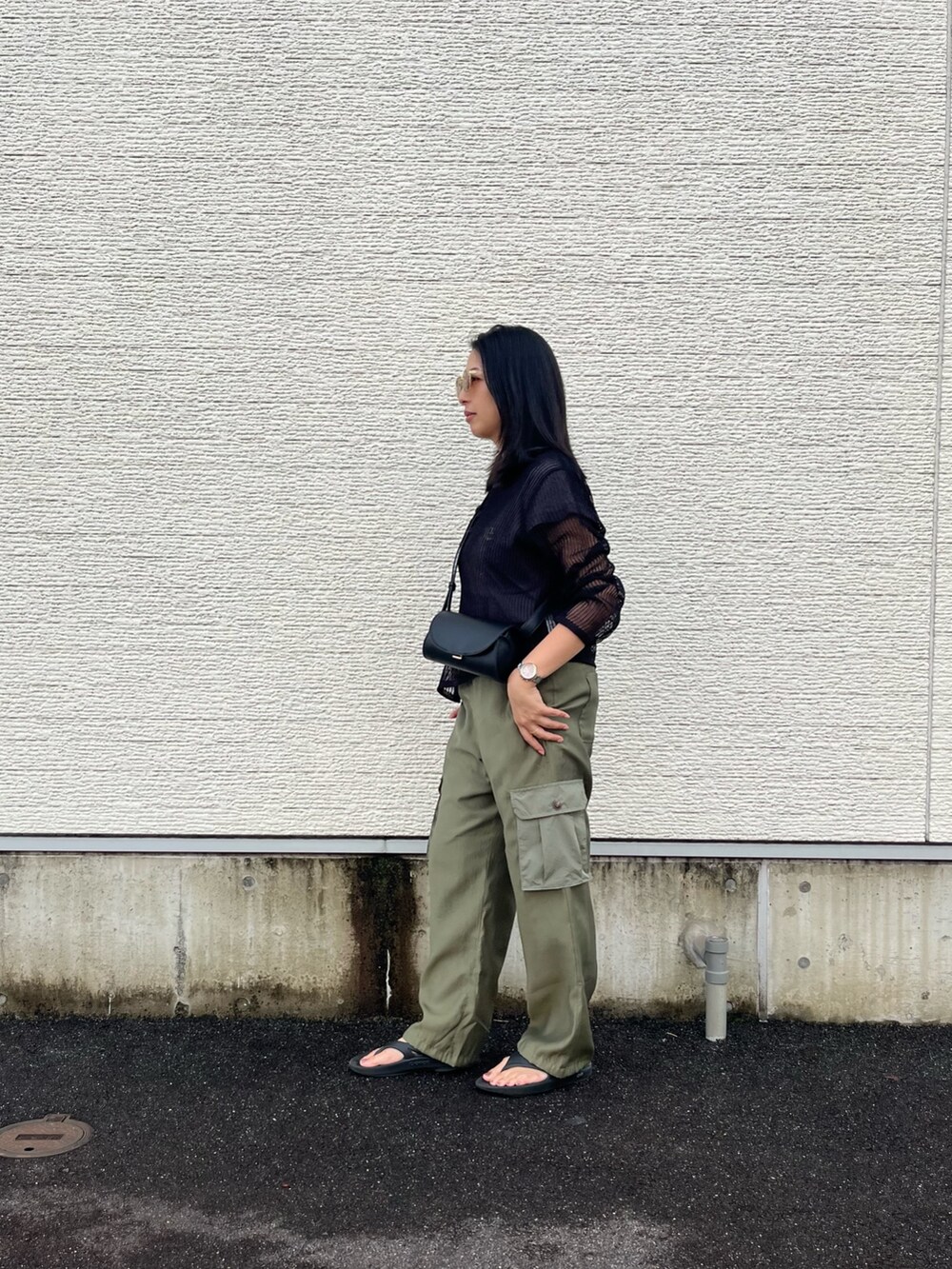 ブラック系のニット/セーター、グレー系のTシャツ/カットソー、グリーン系のカーゴパンツを着用したレディースの夏コーディネートの2枚目の写真