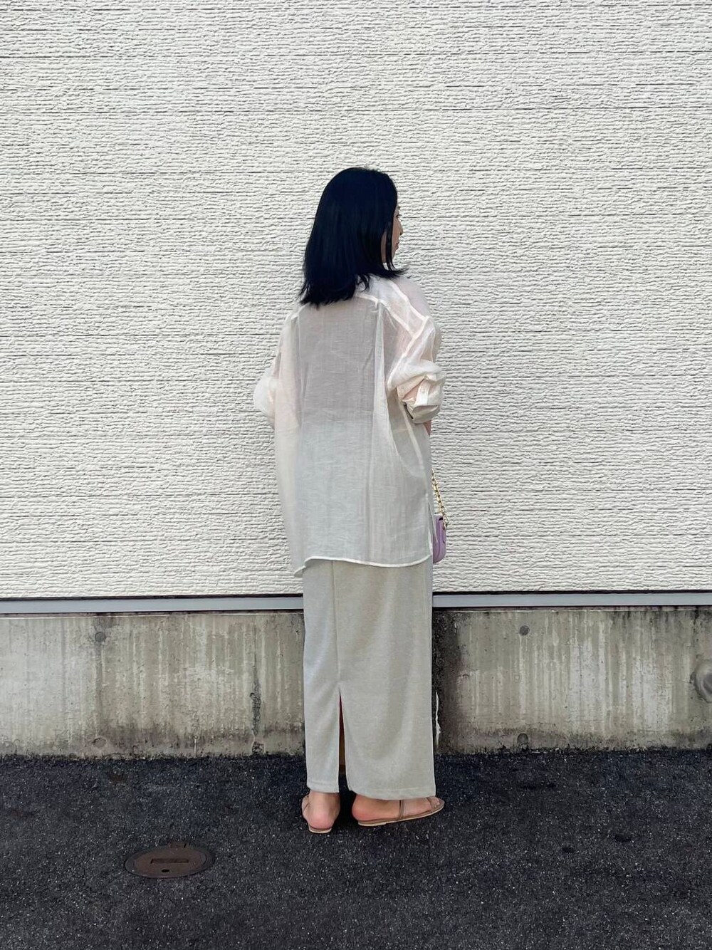 パープル系のショルダーバッグ、ベージュ系のタンクトップ、ベージュ系のスカートを着用したレディースの夏コーディネートの2枚目の写真