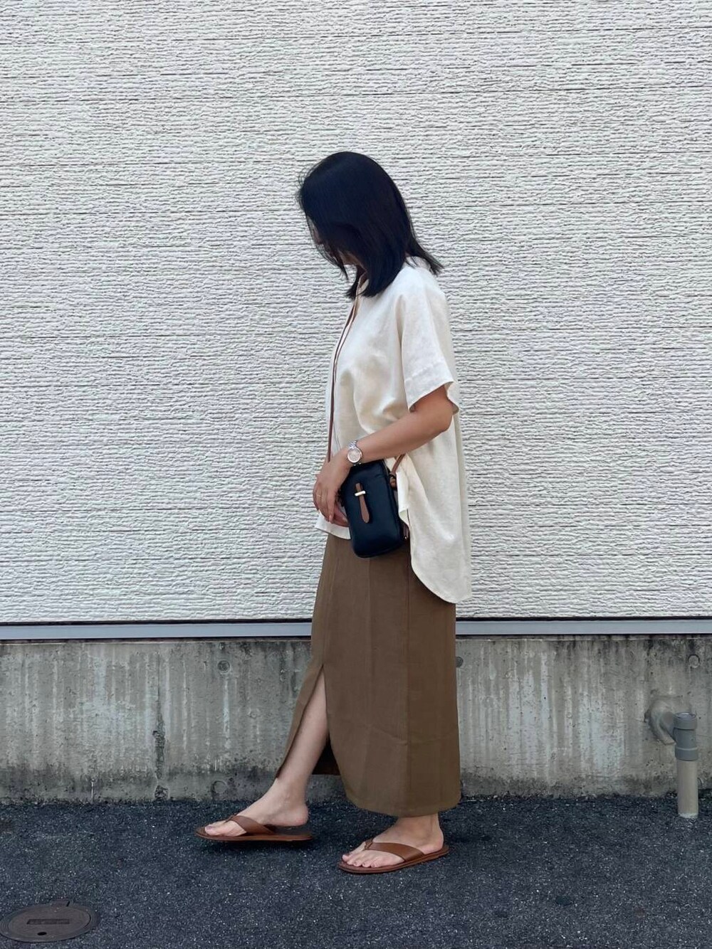 ブラック系のショルダーバッグ、ベージュ系のシャツ/ブラウス、イエロー系のスカートを着用したレディースの夏コーディネートの3枚目の写真