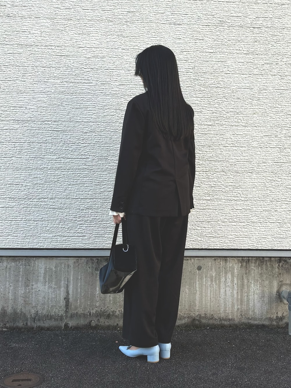 ブラック系のその他アウター、ブルー系のパンプス、ブラック系のその他パンツを着用したレディースの冬コーディネートの2枚目の写真