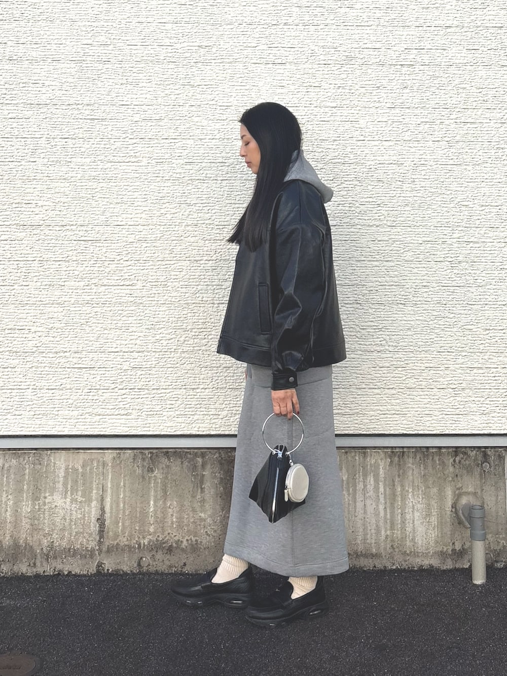 グレー系のスカート、ブラック系のスニーカー、グレー系のパーカーを着用したレディースの春コーディネートの3枚目の写真