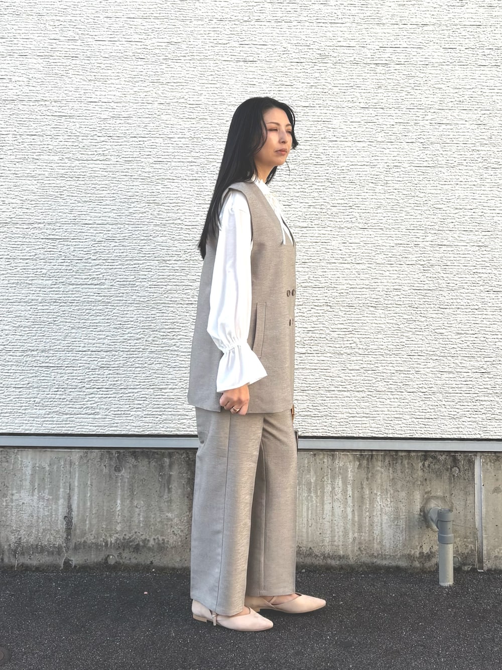 その他のハンドバッグ、ホワイト系のパンプス、ベージュ系のセットアップを着用したレディースの冬コーディネートの4枚目の写真