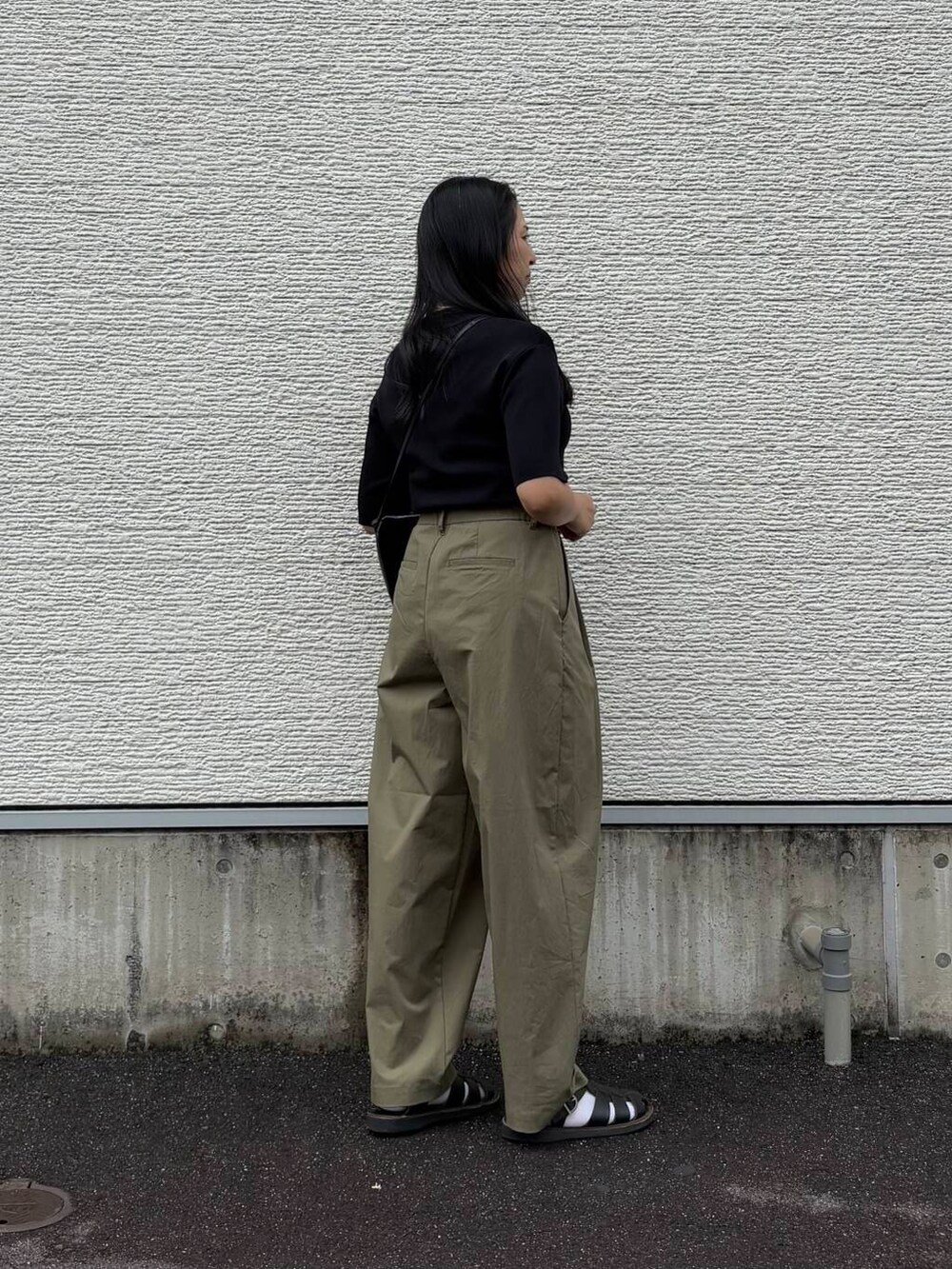 ブラック系のニット/セーター、グリーン系のその他パンツ、ブラック系のショルダーバッグを着用したレディースの春コーディネートの3枚目の写真