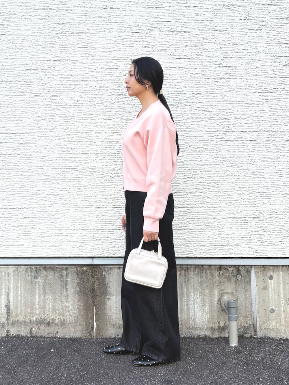 ピンク系のカーディガン/ボレロ、ブラック系のデニムパンツ、ホワイト系のタンクトップを着用したレディースの冬コーディネートの3枚目の写真