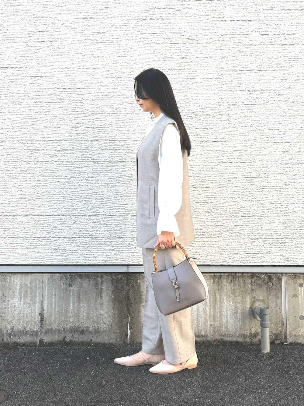 その他のハンドバッグ、ホワイト系のパンプス、ベージュ系のセットアップを着用したレディースの冬コーディネートの2枚目の写真