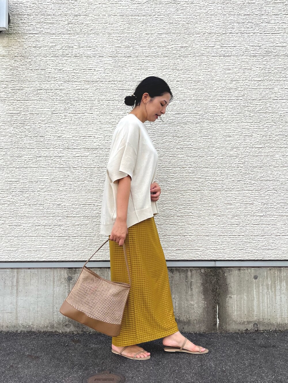 ベージュ系のショルダーバッグ、ホワイト系のニット/セーター、イエロー系のスカートを着用したレディースの秋コーディネートの3枚目の写真
