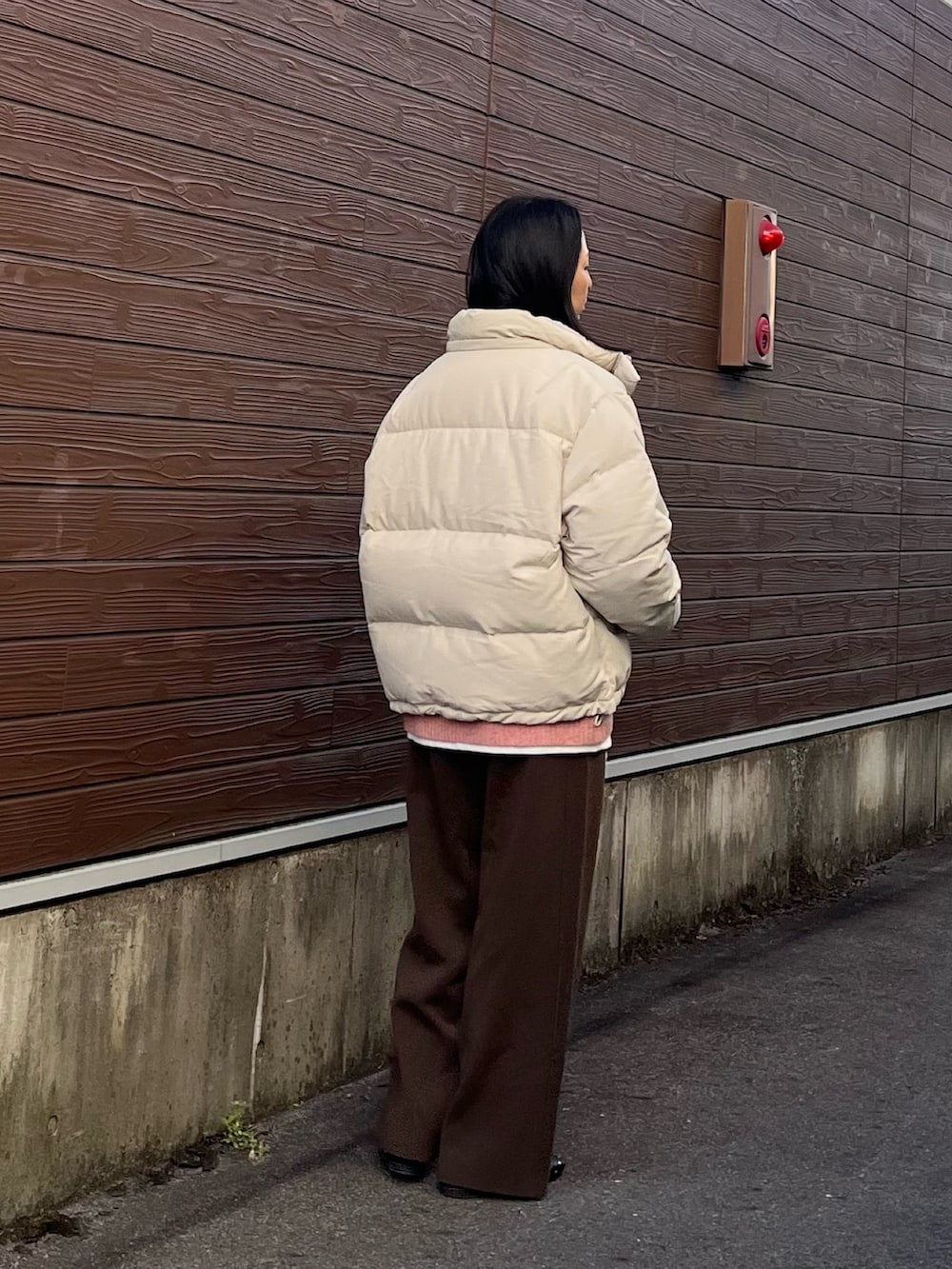 ピンク系のニット/セーター、グレー系のダウンジャケット/コート、ホワイト系のTシャツ/カットソーを着用したレディースの冬コーディネートの2枚目の写真