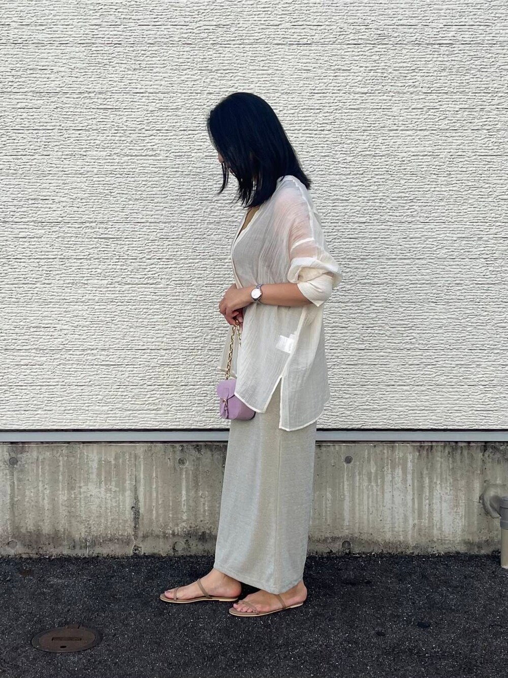 パープル系のショルダーバッグ、ベージュ系のタンクトップ、ベージュ系のスカートを着用したレディースの夏コーディネートの3枚目の写真