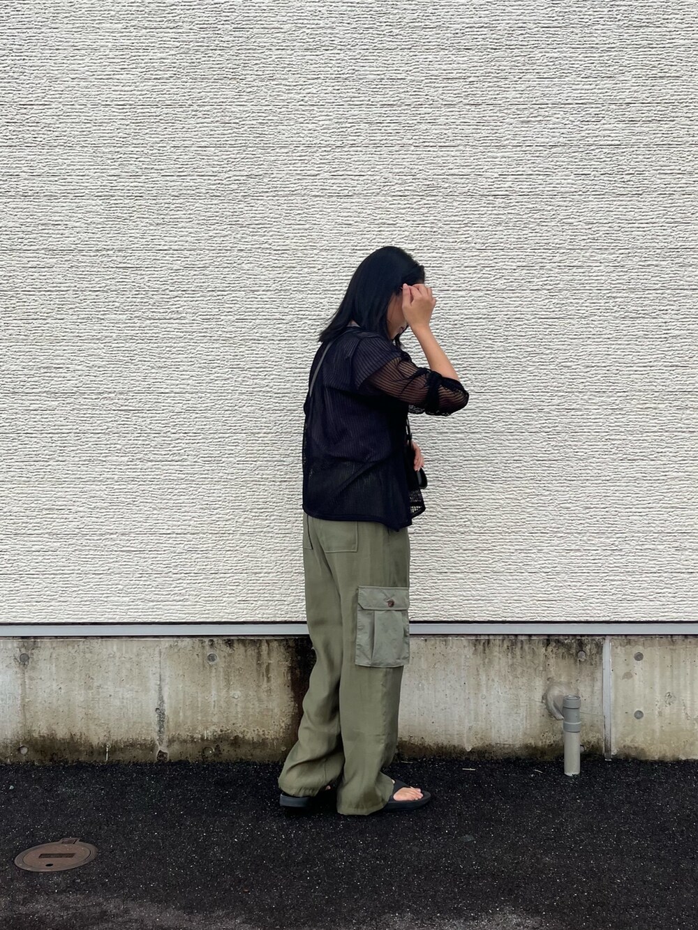 ブラック系のニット/セーター、グレー系のTシャツ/カットソー、グリーン系のカーゴパンツを着用したレディースの夏コーディネートの3枚目の写真