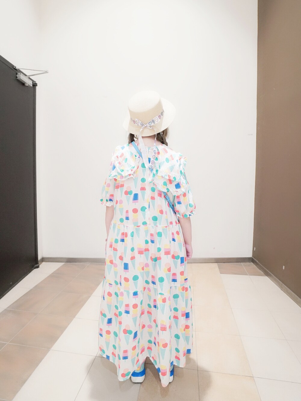 ブルー系のバッグ、その他のスニーカー、ベージュ系の帽子を着用したレディースの夏コーディネートの2枚目の写真