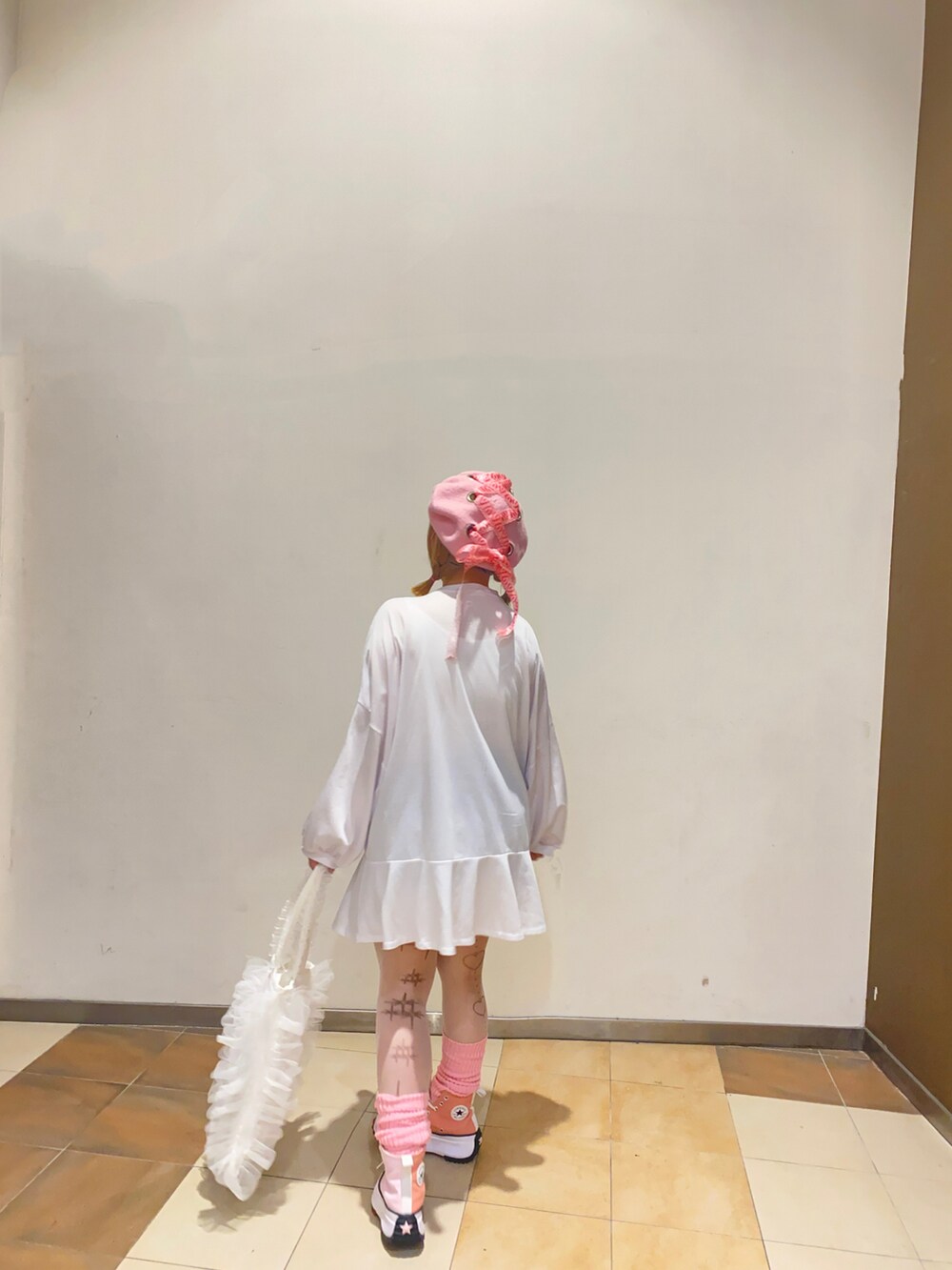 ピンク系のスニーカーを着用したレディースの秋コーディネートの2枚目の写真