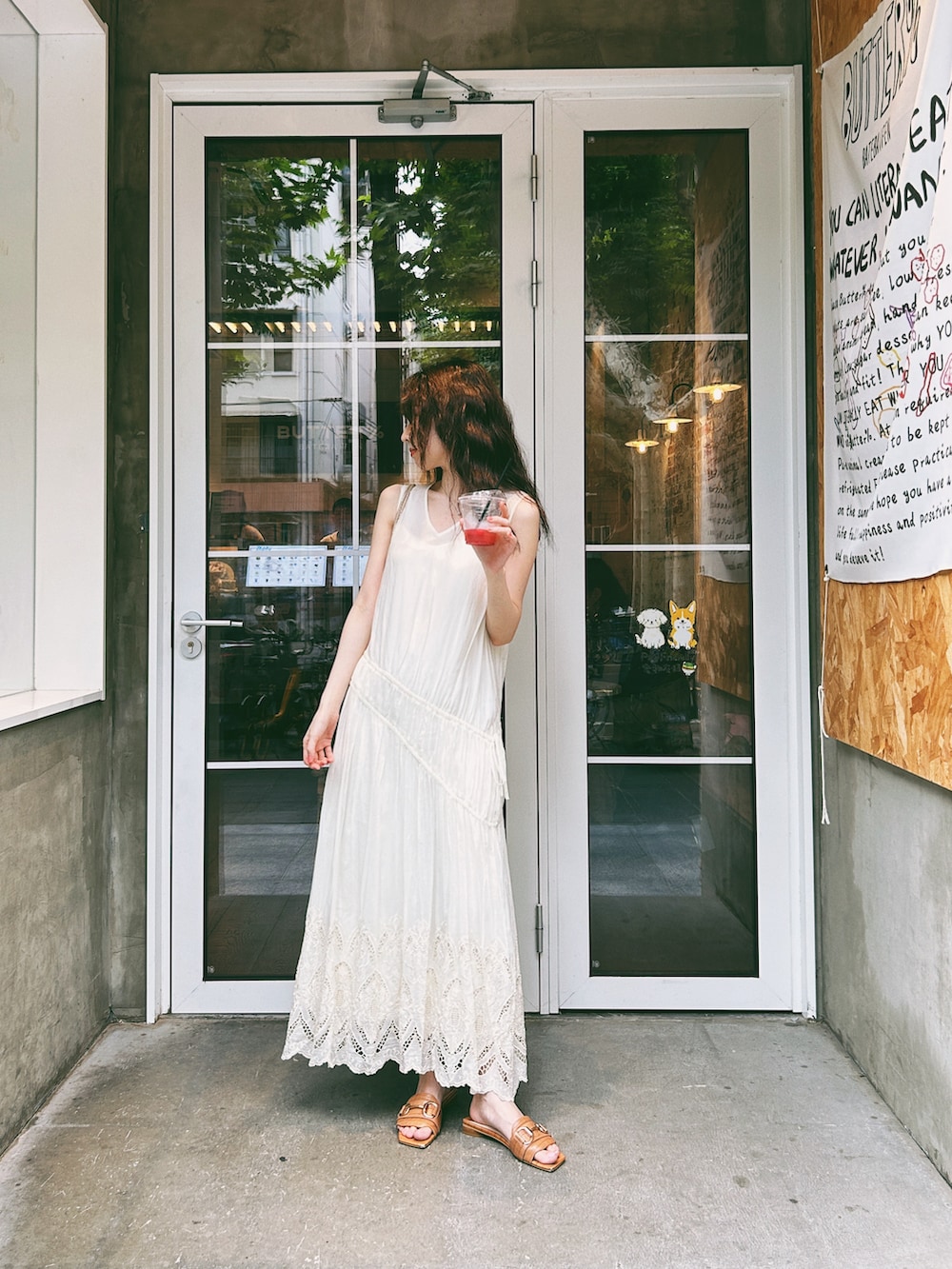 ブラウン系のサンダル、ゴールド系のバッグ、ホワイト系のジャンパースカートを着用したレディースの秋コーディネートの2枚目の写真