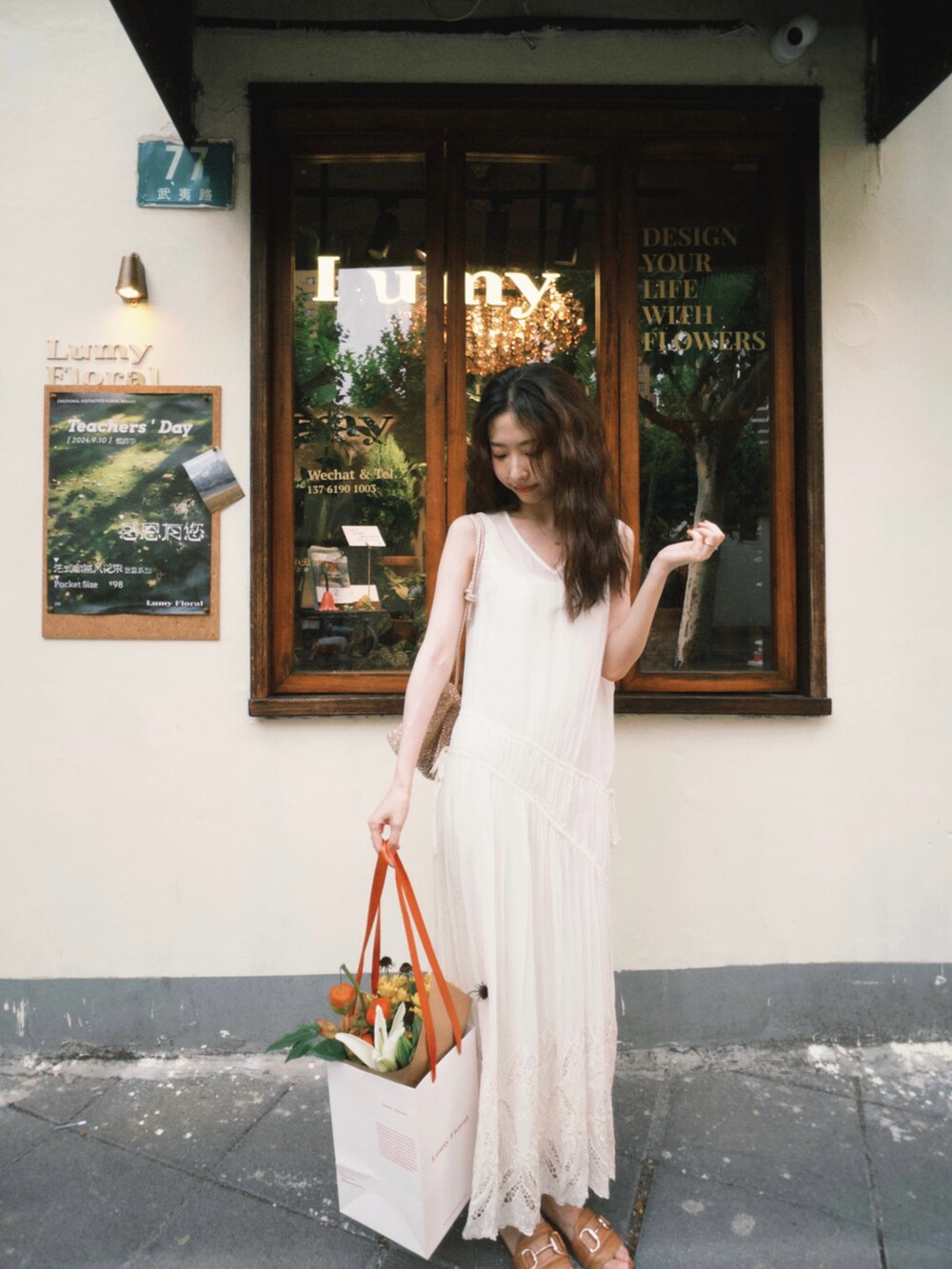 ブラウン系のサンダル、ゴールド系のバッグ、ホワイト系のジャンパースカートを着用したレディースの秋コーディネートの4枚目の写真