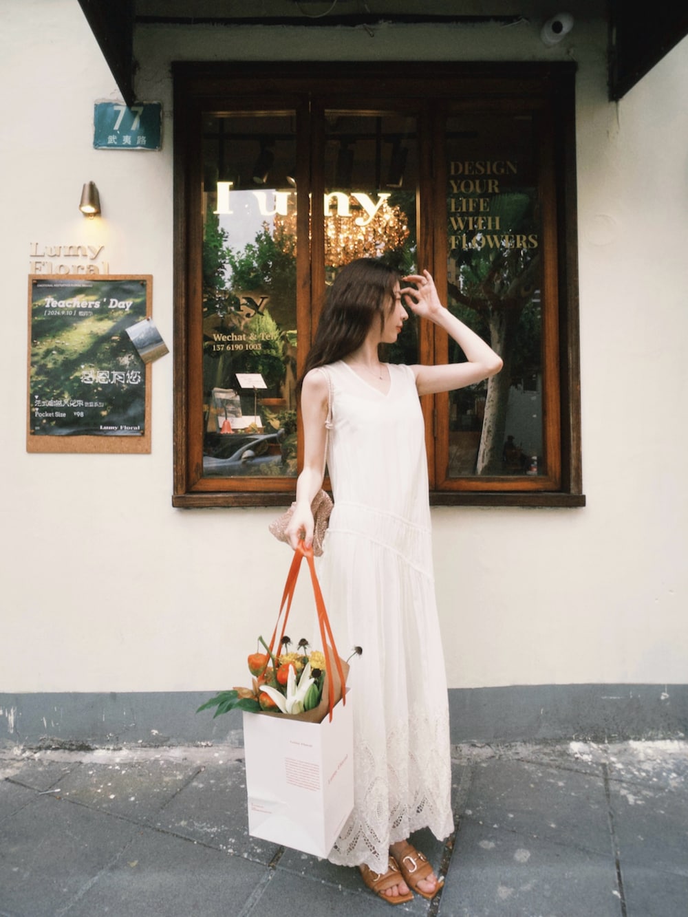 ブラウン系のサンダル、ゴールド系のバッグ、ホワイト系のジャンパースカートを着用したレディースの秋コーディネートの3枚目の写真