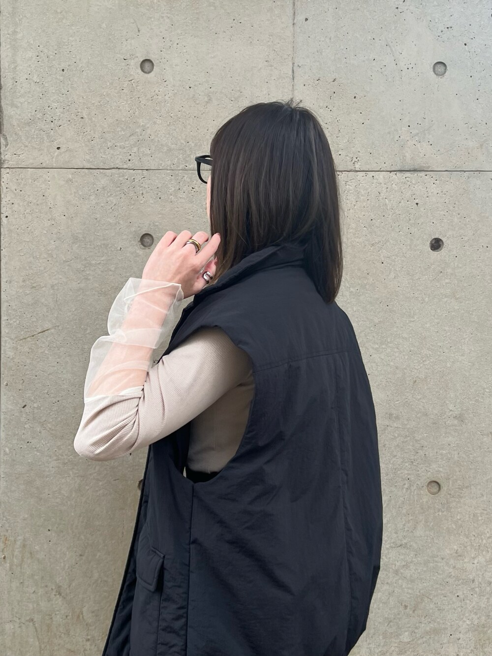 ベージュ系のTシャツ/カットソー、ブラック系のジャンパースカート、ブラック系のバッグを着用したレディースの春コーディネートの3枚目の写真