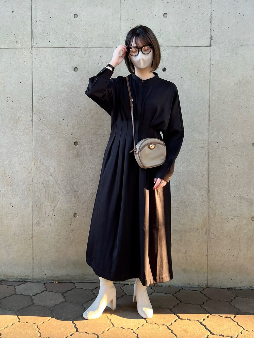 ブラック系のワンピース、ブラウン系のショルダーバッグ、ホワイト系のブーツを着用したレディースの秋コーディネートの2枚目の写真
