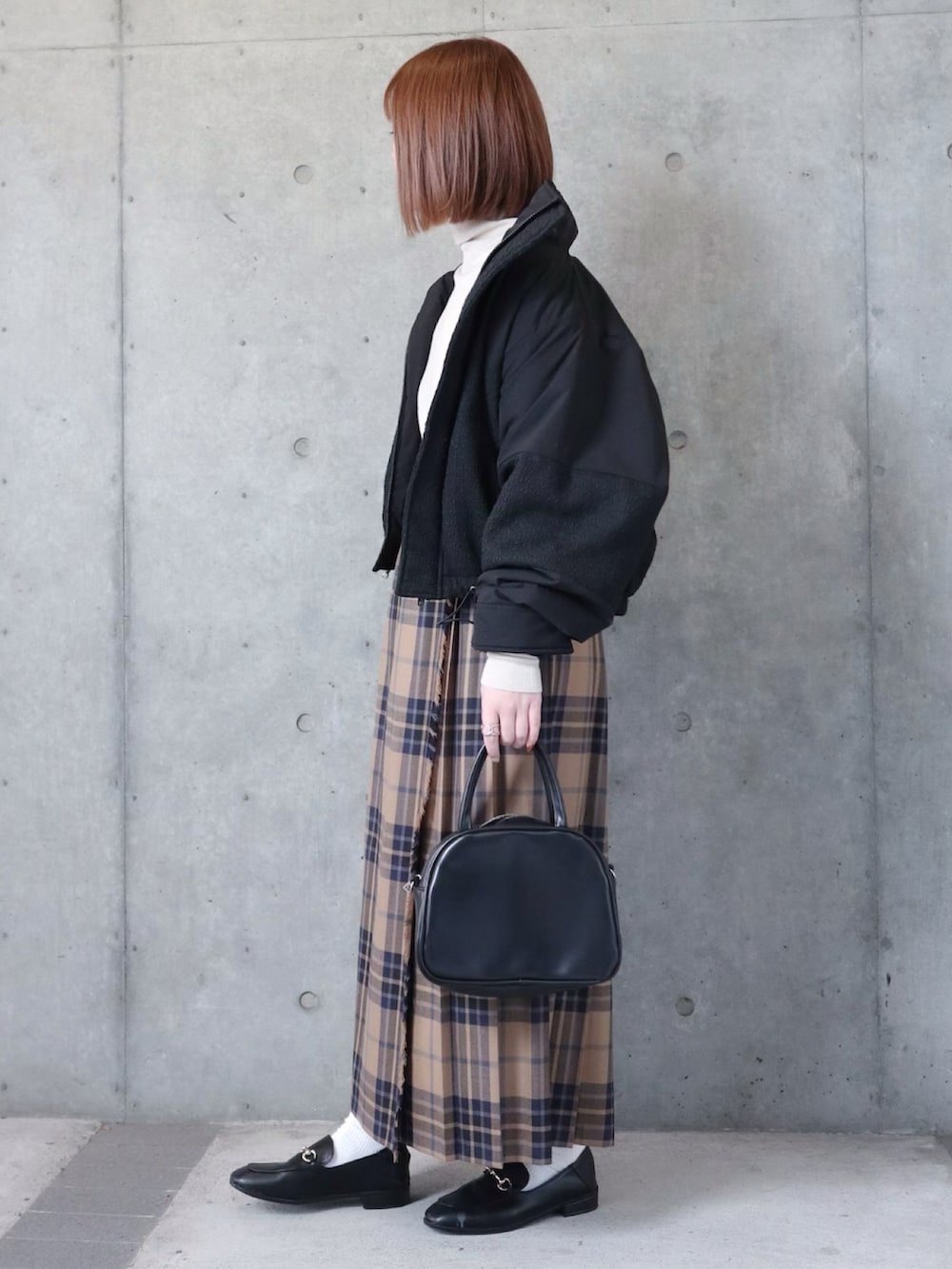 ブラック系のダウンジャケット/コート、ブラック系のニット/セーター、ベージュ系のスカートを着用したレディースの秋コーディネートの2枚目の写真