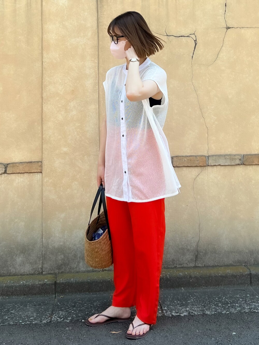 オレンジ系のスラックス、ホワイト系のシャツ/ブラウス、ブラック系のキャミソールを着用したレディースの夏コーディネートの2枚目の写真