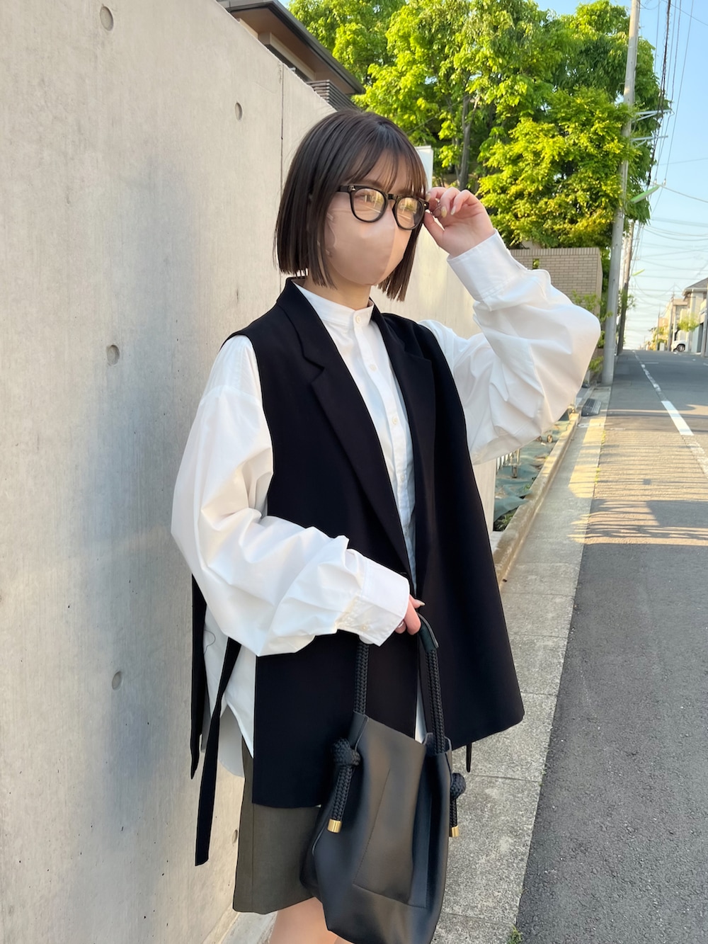 グリーン系のその他パンツ、ホワイト系のシャツ/ブラウス、ブラック系のハンドバッグを着用したレディースの春コーディネートの2枚目の写真