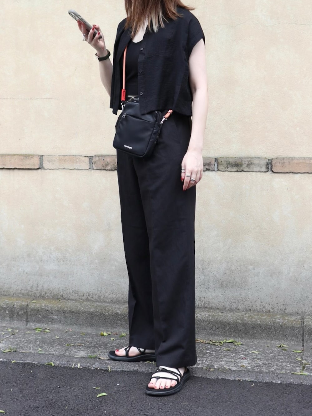 ブラック系のキャミソール、ブラック系のパンツ、ブラック系のサンダルを着用したレディースの夏コーディネートの2枚目の写真