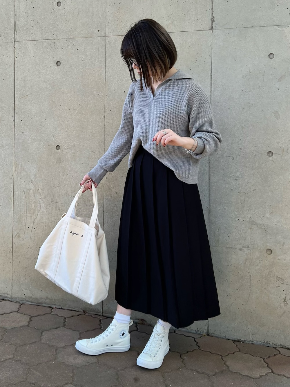 グレー系のニット/セーター、ブラック系のスカート、ホワイト系のトートバッグを着用したレディースの秋コーディネートの2枚目の写真