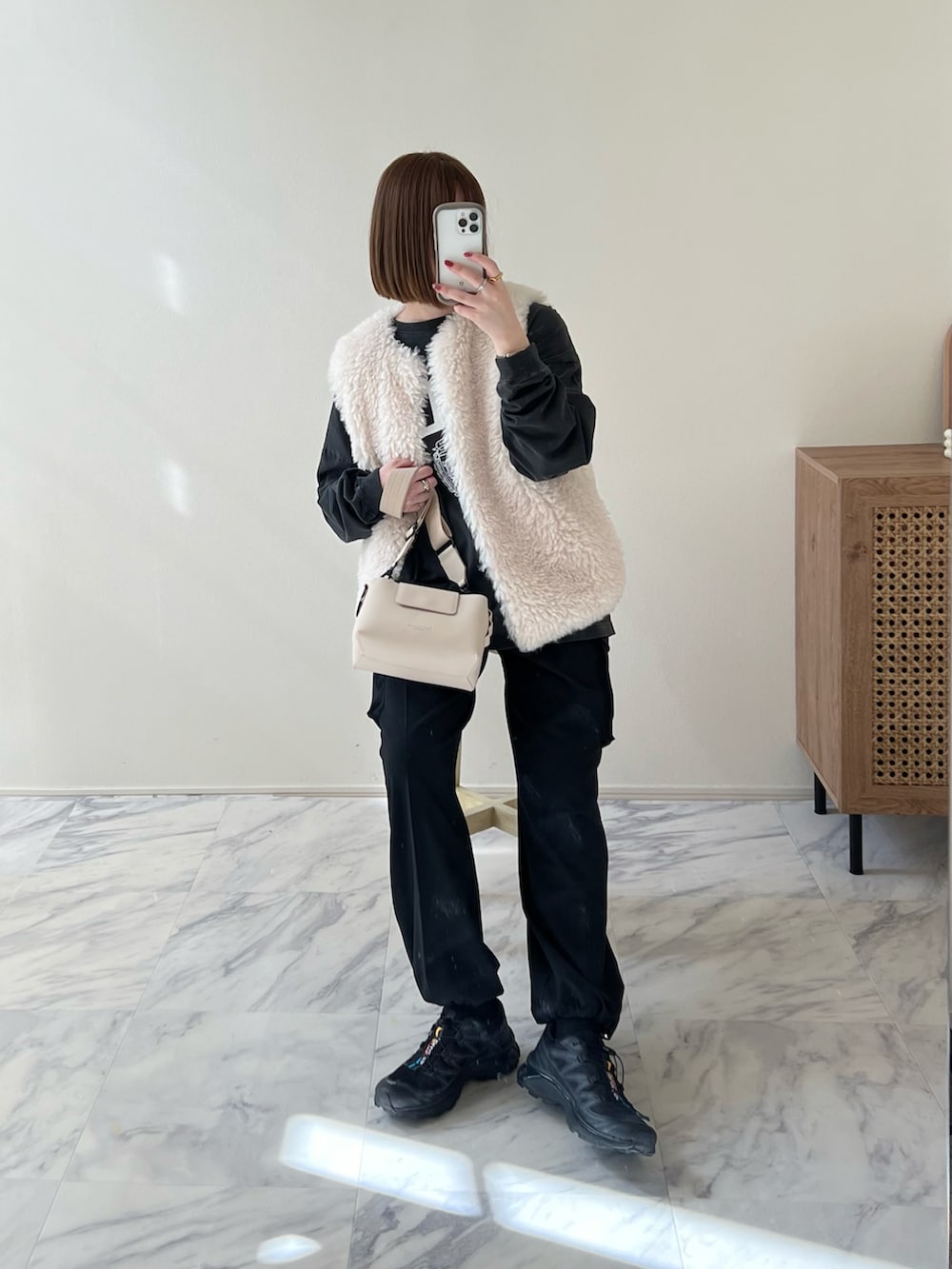 ブラック系のその他パンツ、ベージュ系のショルダーバッグ、ブラック系のスニーカーを着用したレディースの冬コーディネートの2枚目の写真