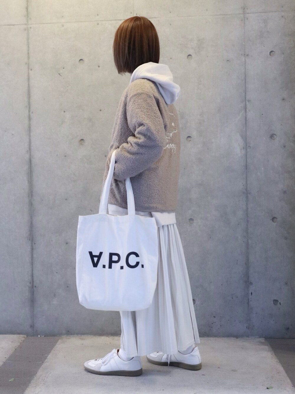 ベージュ系のダウンジャケット/コート、ホワイト系のパーカー、ホワイト系のトートバッグを着用したレディースの秋コーディネートの3枚目の写真