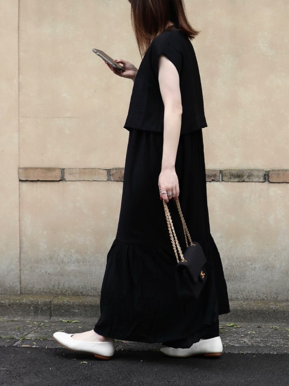 ブラック系のシャツ/ブラウス、ブラック系のワンピース、ホワイト系のパンプスを着用したレディースの夏コーディネートの3枚目の写真