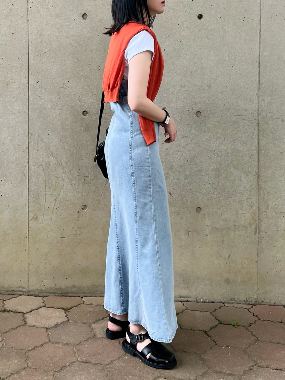 ブルー系のワンピース、ホワイト系のTシャツ/カットソー、オレンジ系のカーディガン/ボレロを着用したレディースの春コーディネートの2枚目の写真