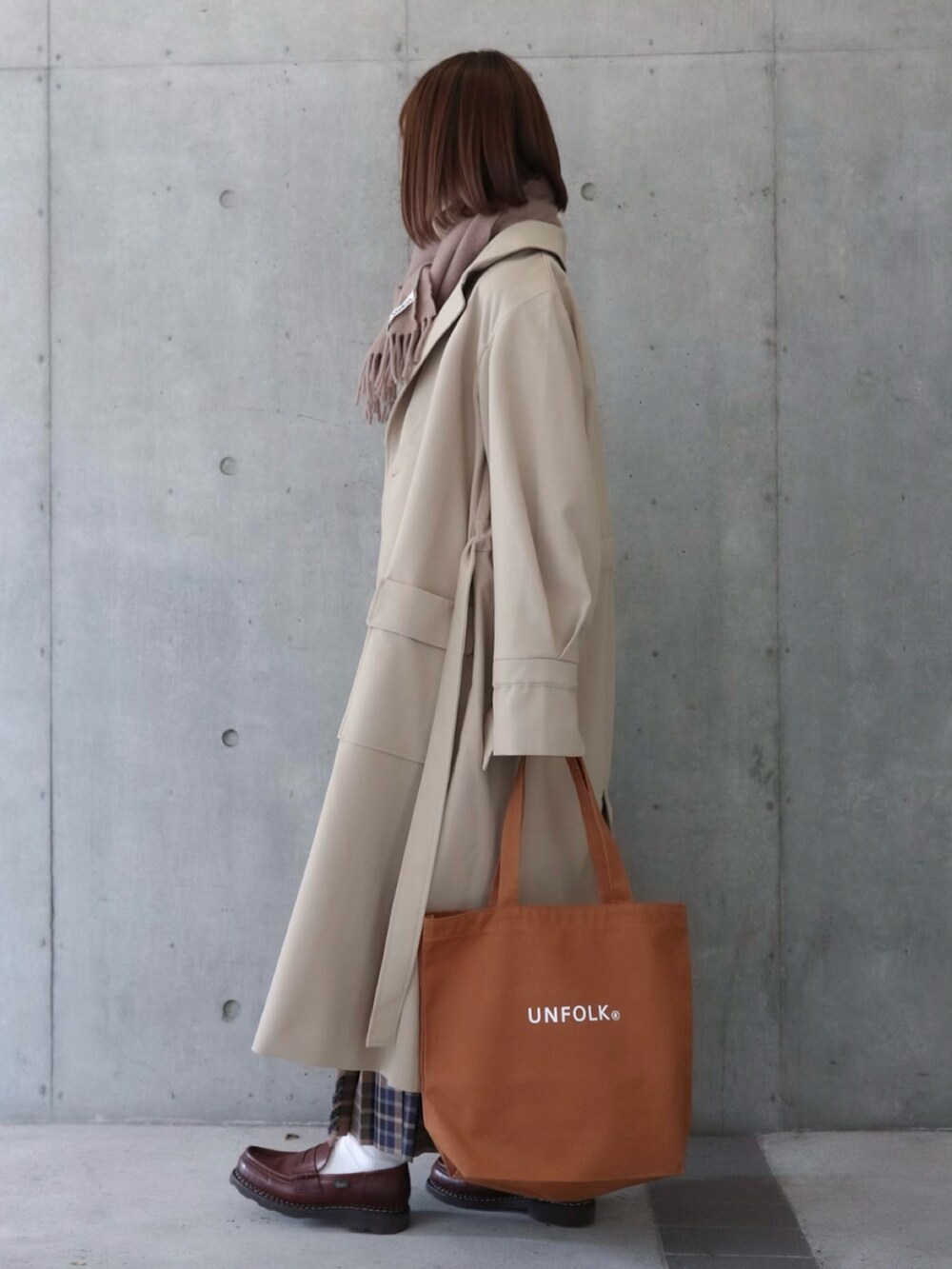 ベージュ系のトレンチコート、ベージュ系のスカート、ベージュ系のニット/セーターを着用したレディースの春コーディネートの2枚目の写真
