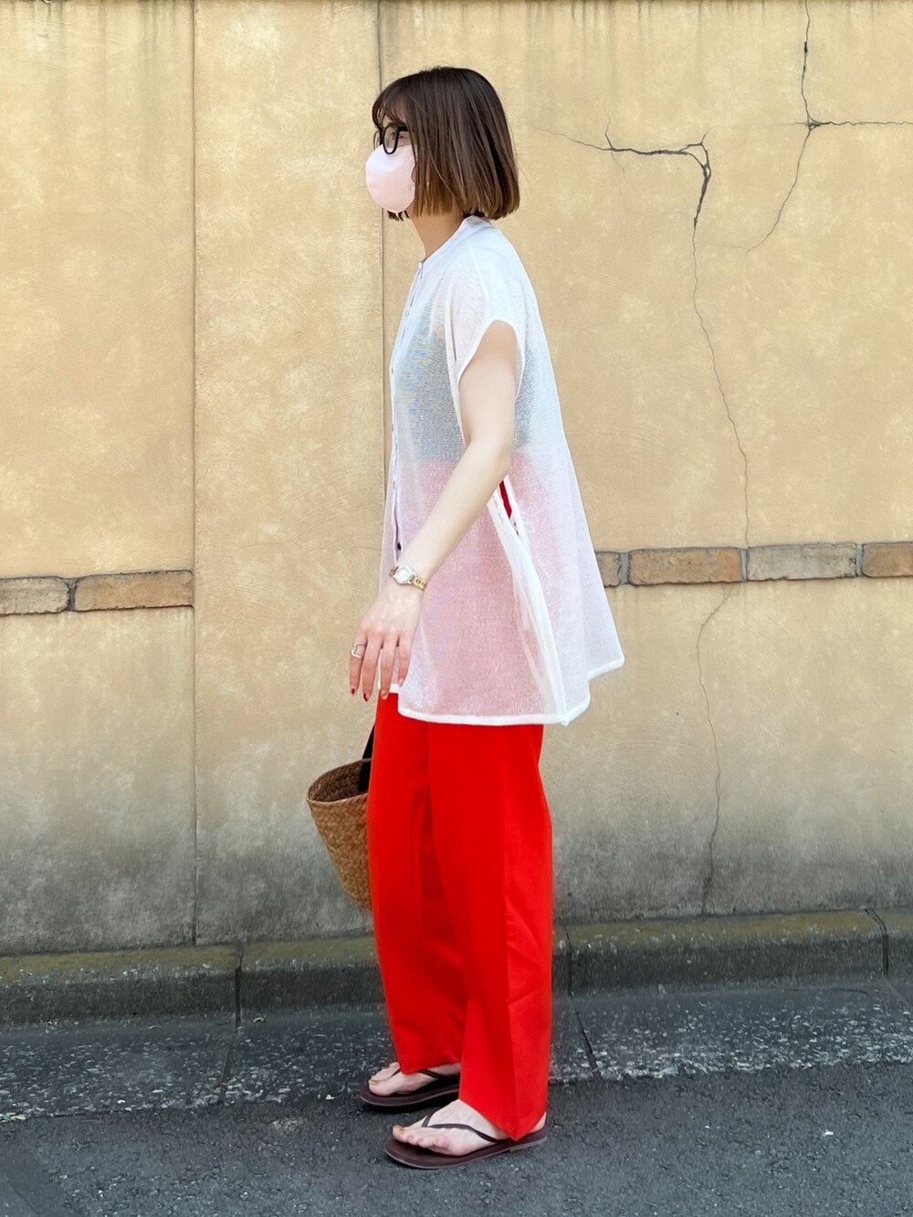 オレンジ系のスラックス、ホワイト系のシャツ/ブラウス、ブラック系のキャミソールを着用したレディースの夏コーディネートの3枚目の写真