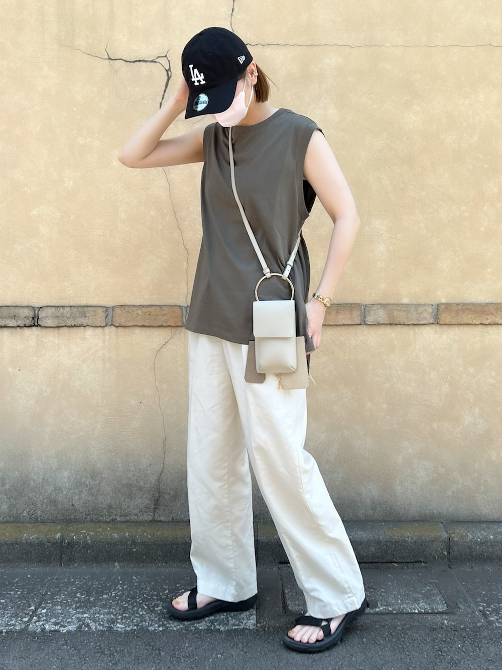 グリーン系のTシャツ/カットソー、ベージュ系のショルダーバッグ、ホワイト系のパンツを着用したレディースの夏コーディネートの2枚目の写真
