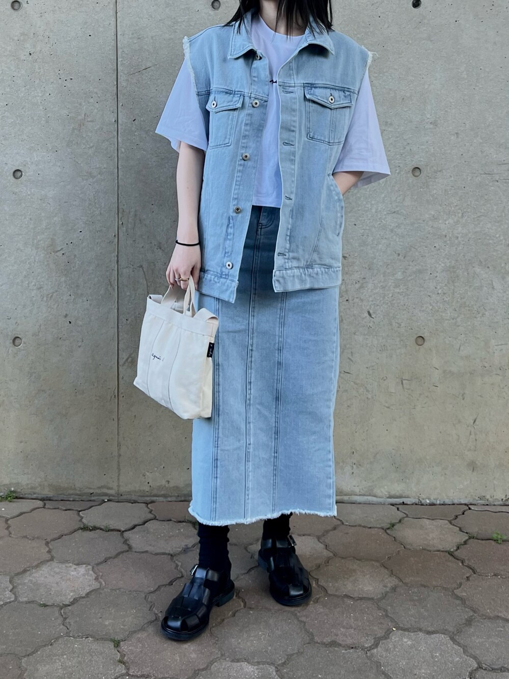 ブルー系のベスト、ブルー系のデニムスカート、ホワイト系のTシャツ/カットソーを着用したレディースの春コーディネートの2枚目の写真
