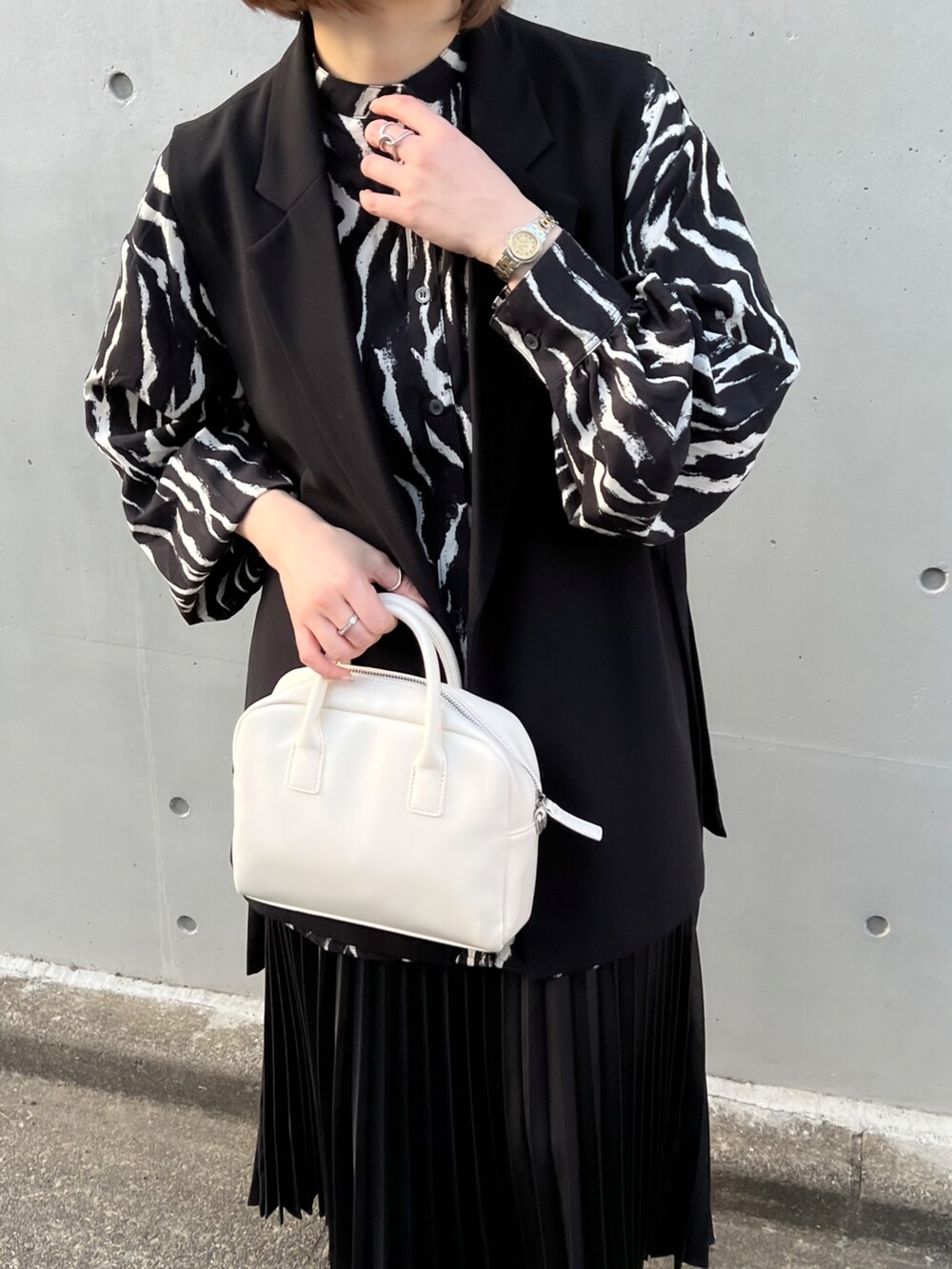 ブラック系のシャツ/ブラウス、ブラック系のスカート、ホワイト系のボストンバッグを着用したレディースの春コーディネートの4枚目の写真