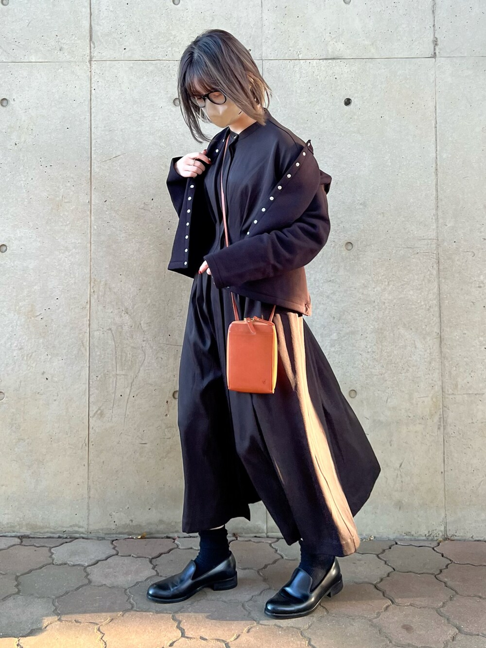 ブラック系のワンピース、ブラック系のカーディガン/ボレロ、イエロー系のショルダーバッグを着用したレディースの秋コーディネートの2枚目の写真