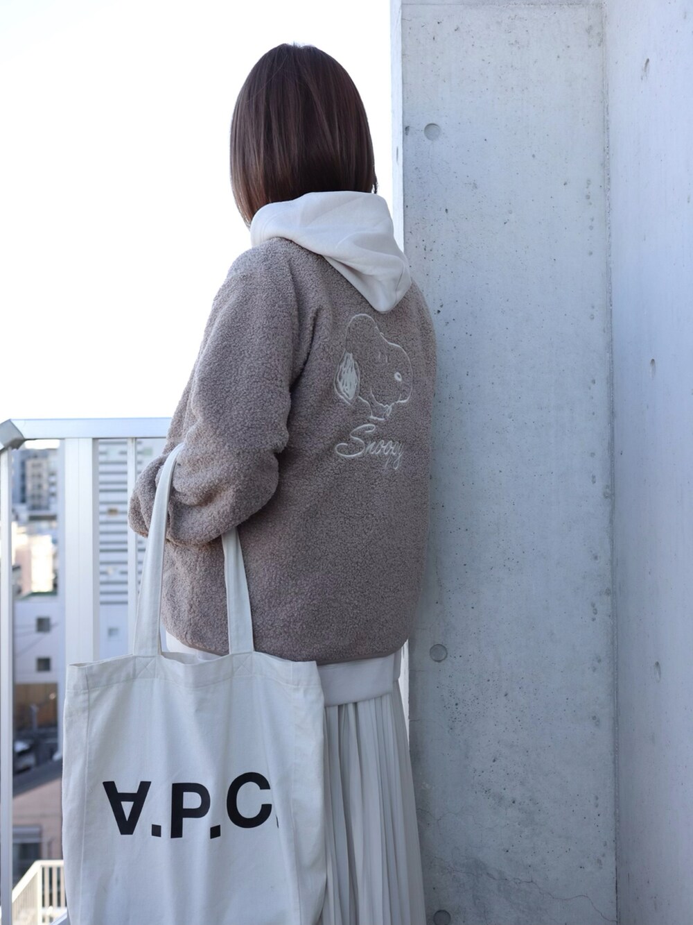 ベージュ系のダウンジャケット/コート、ホワイト系のパーカー、ホワイト系のトートバッグを着用したレディースの秋コーディネートの4枚目の写真