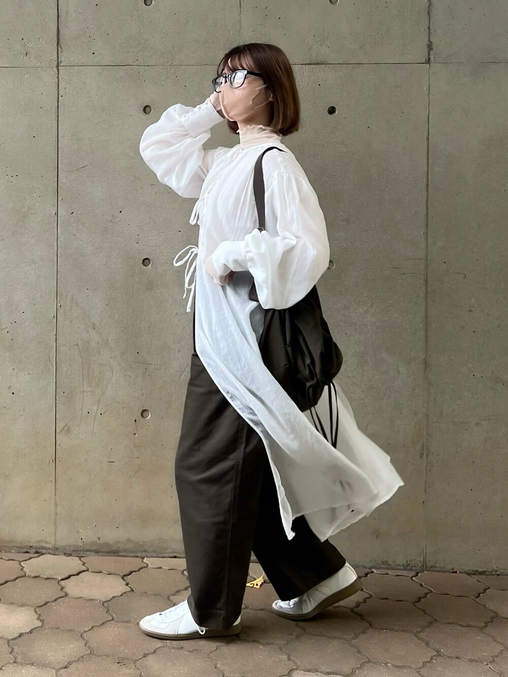 ホワイト系のワンピース、ホワイト系のTシャツ/カットソー、グリーン系のショルダーバッグを着用したレディースの秋コーディネートの2枚目の写真