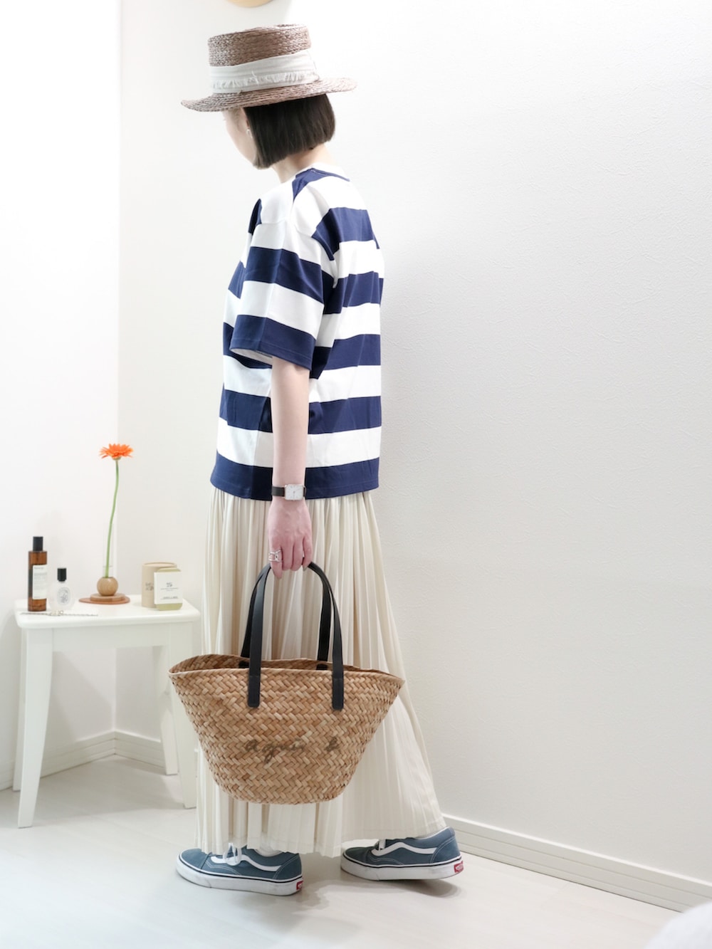 ブルー系のTシャツ/カットソー、ブラック系のかごバッグ、ホワイト系のスカートを着用したレディースの夏コーディネートの2枚目の写真