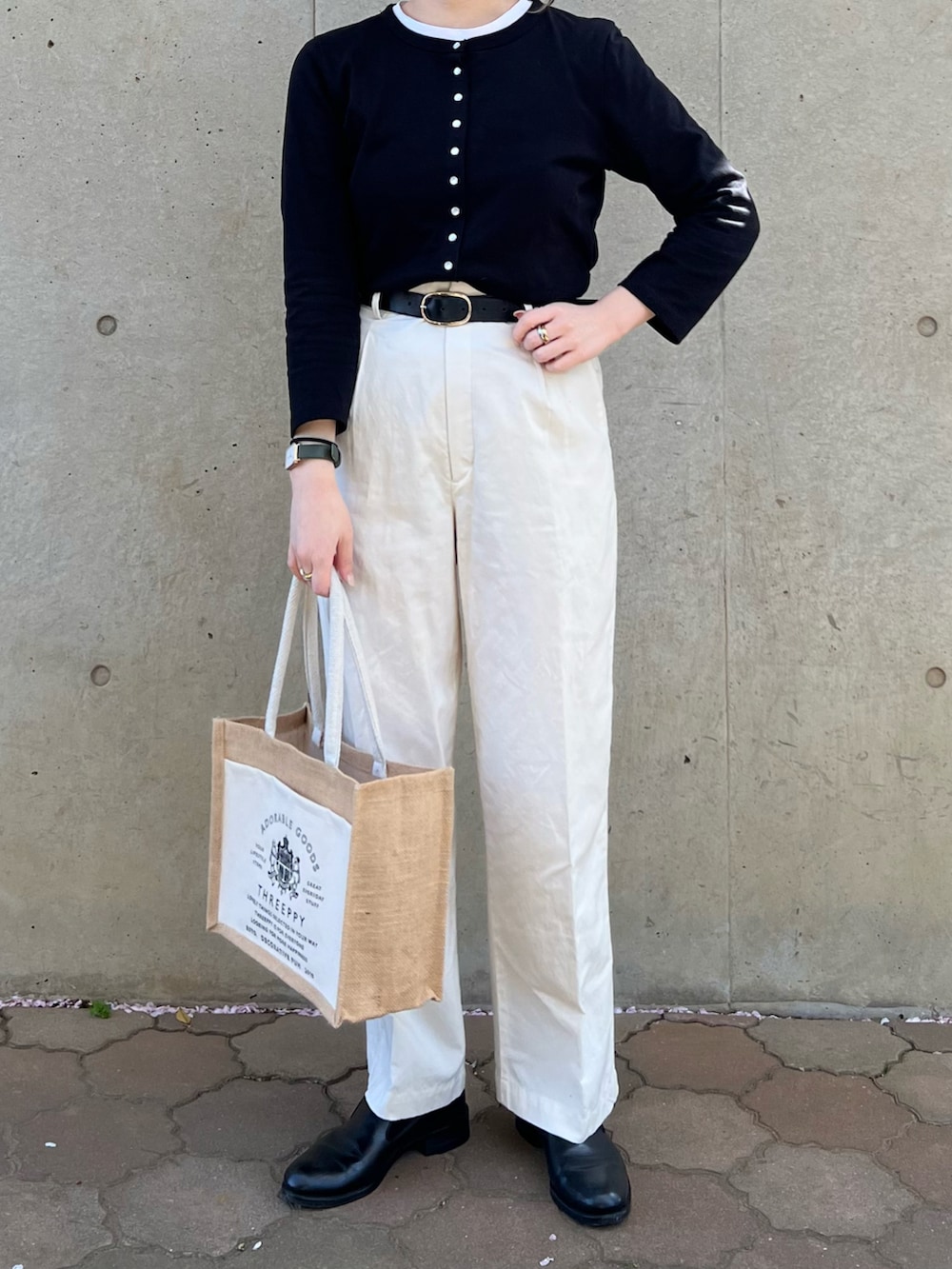 ブラック系のカーディガン/ボレロ、ホワイト系のパンツ、ブラック系のシューズを着用したレディースの春コーディネートの2枚目の写真